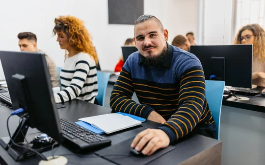 Junger Mann im Computerkurs